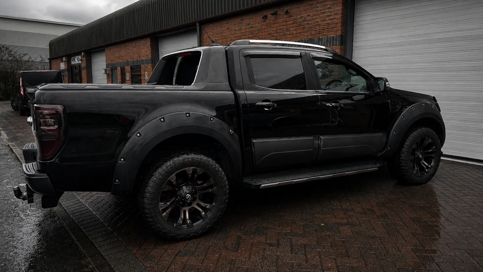 Black Ford Ranger pickup with a detailed gloss finish and black alloy wheels outside the AutoPerfect unit in Stone, Staffordshire